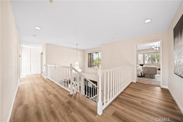 hallway featuring hardwood / wood-style flooring and a chandelier