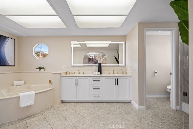 bathroom with tile patterned floors, a tub to relax in, vanity, and toilet