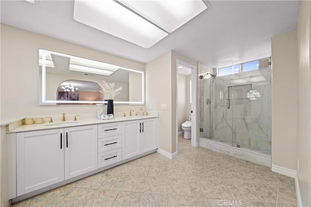 bathroom with walk in shower, vanity, and toilet