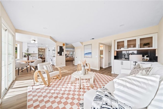 living room with light hardwood / wood-style flooring and sink