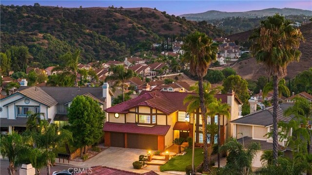 aerial view at dusk featuring a mountain view