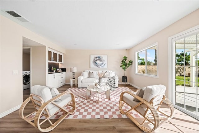 living room with washer / dryer and light hardwood / wood-style floors