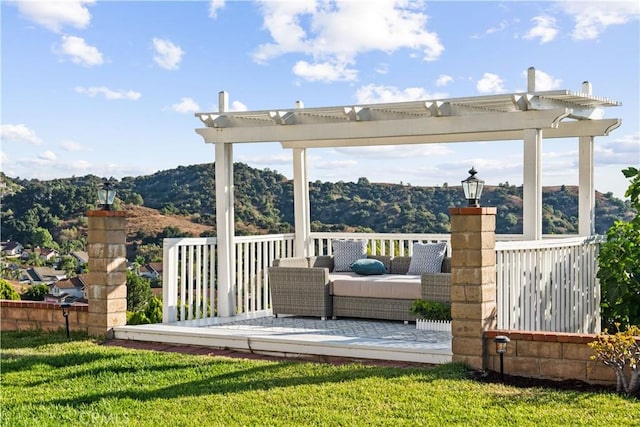 wooden terrace featuring a mountain view, a pergola, outdoor lounge area, and a yard