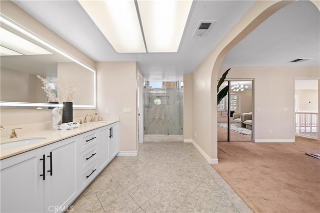 bathroom with tile patterned floors, walk in shower, and vanity