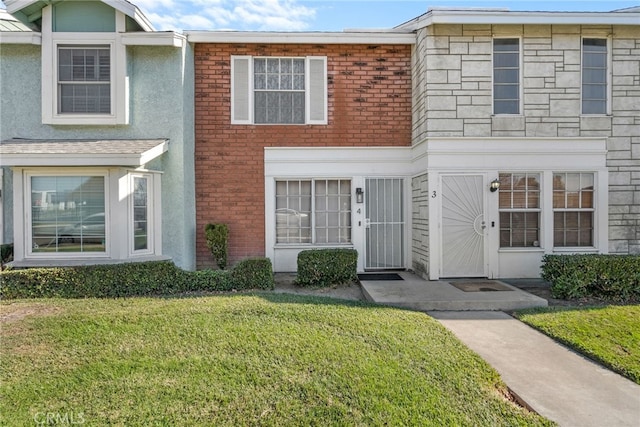 townhome / multi-family property featuring a front yard