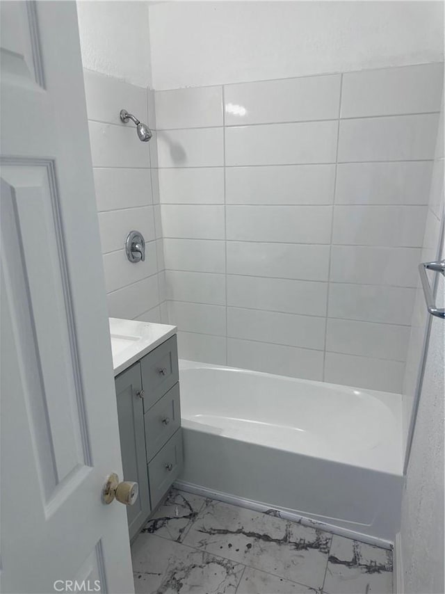 bathroom with tiled shower / bath and vanity