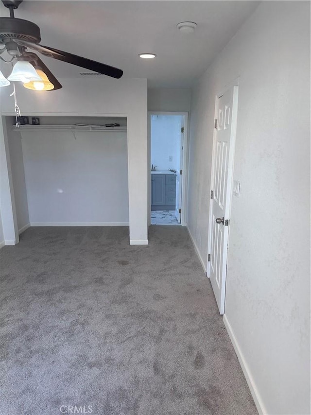 interior space with ceiling fan, a closet, and carpet flooring