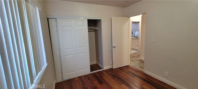 unfurnished bedroom featuring a closet and dark hardwood / wood-style flooring