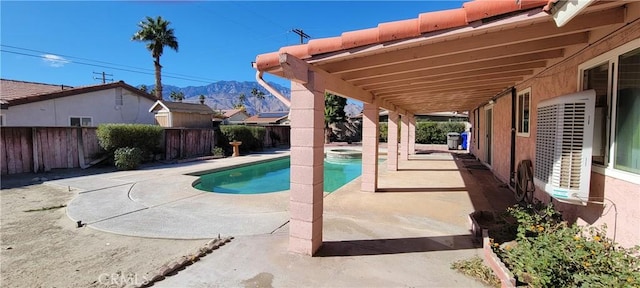 view of swimming pool featuring a patio area and a mountain view