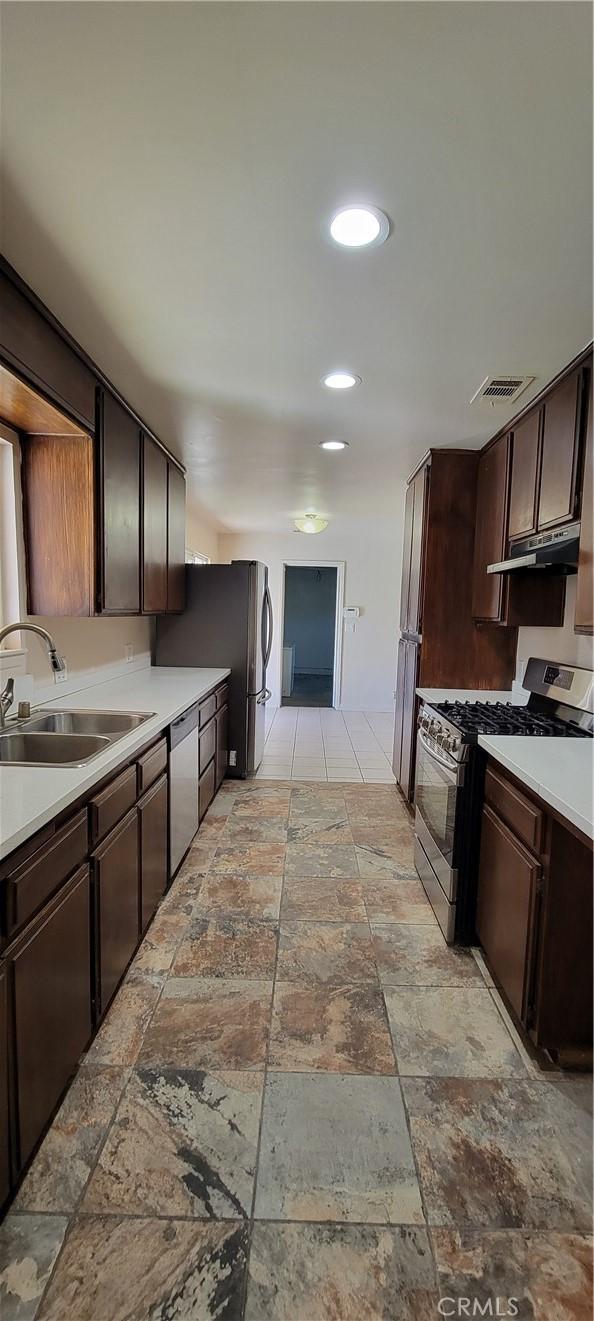 kitchen featuring sink, stainless steel appliances, and dark brown cabinets