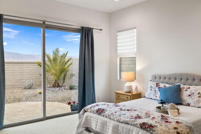 carpeted bedroom featuring access to exterior and multiple windows