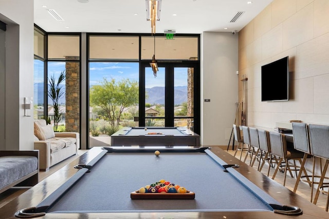 recreation room with a wall of windows and pool table