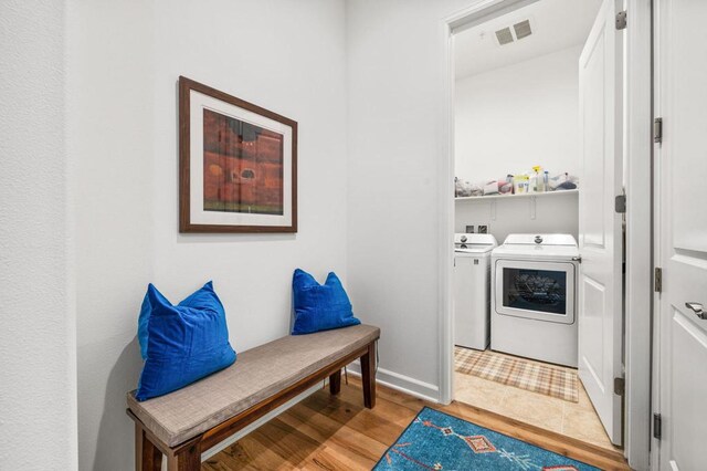 laundry room featuring light hardwood / wood-style flooring and washing machine and clothes dryer