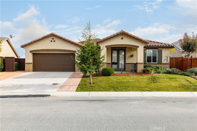 mediterranean / spanish-style house with french doors, a garage, and a front yard