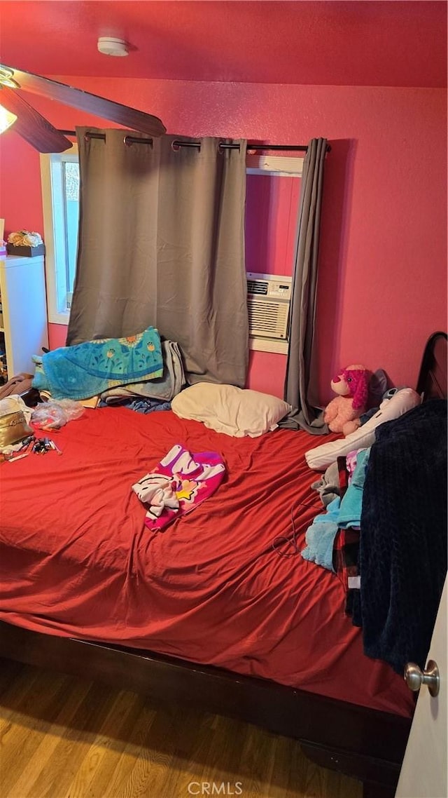 bedroom with washer / dryer, cooling unit, and wood-type flooring