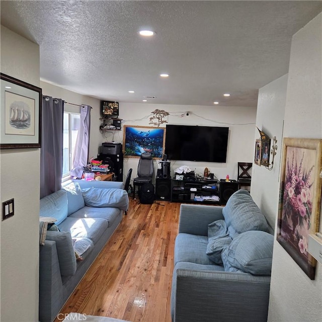 living room with wood-type flooring and a textured ceiling