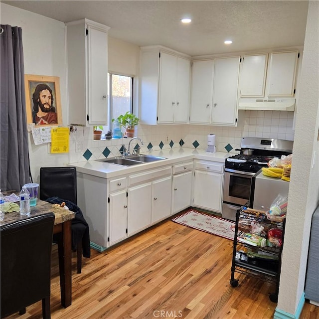 kitchen featuring white cabinetry, sink, gas stove, and light wood-type flooring