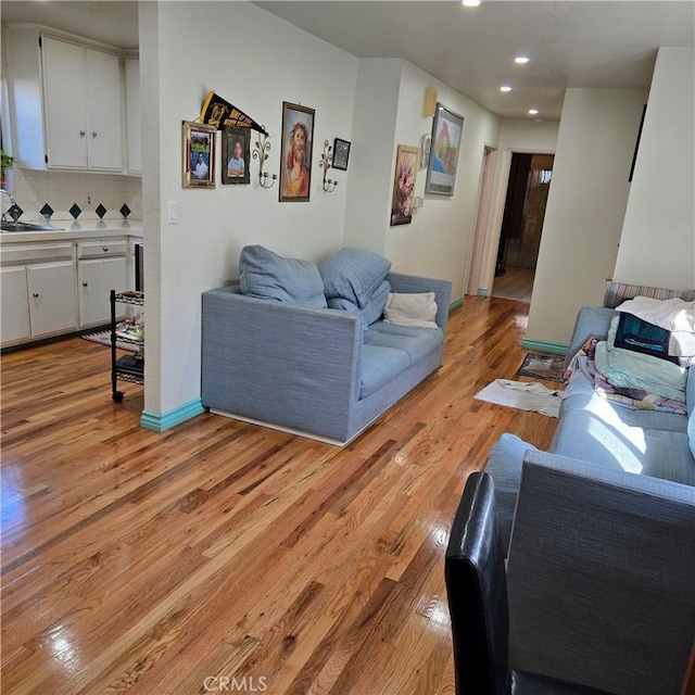 living room featuring sink and light hardwood / wood-style flooring