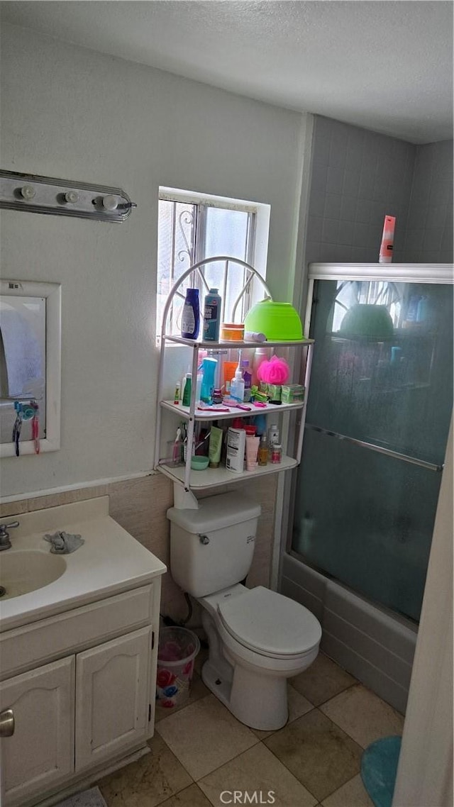 full bathroom with toilet, vanity, tile patterned flooring, and shower / bath combination with glass door