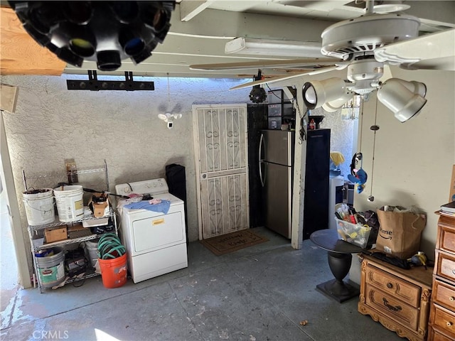 basement featuring ceiling fan, washer / clothes dryer, and stainless steel refrigerator