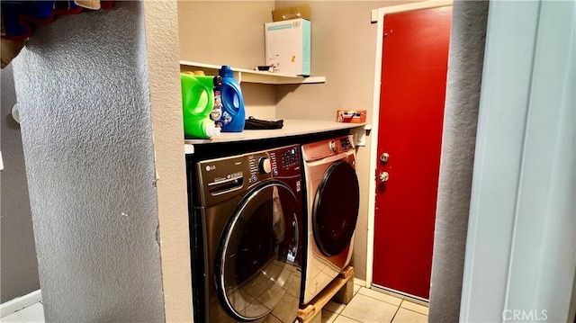 laundry area featuring washer and dryer and light tile patterned flooring