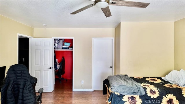 bedroom with dark wood-type flooring, ceiling fan, and a closet