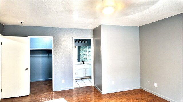11807 Lupin Rd, Adelanto, CA 92301 - unfurnished bedroom with a spacious closet, a sink, wood finished floors, a closet, and ensuite bath