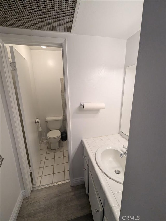 bathroom with wood-type flooring, toilet, and vanity