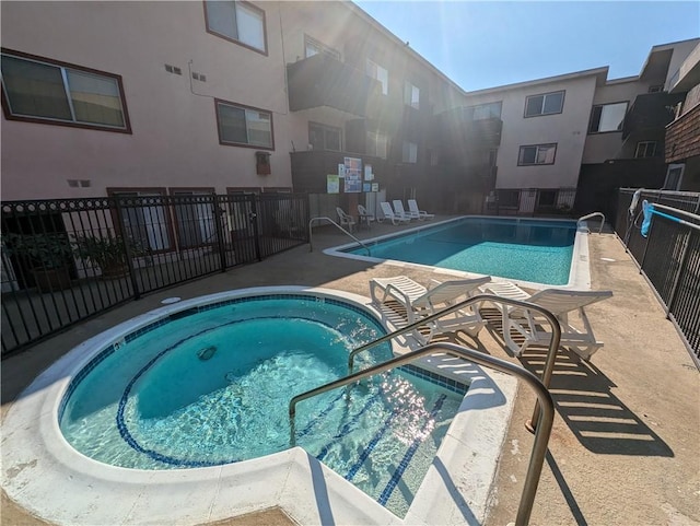 view of pool featuring a community hot tub and a patio area