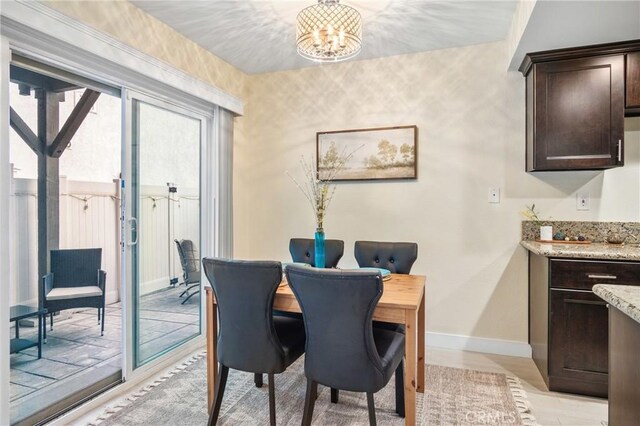 dining area with light wood-type flooring and a notable chandelier