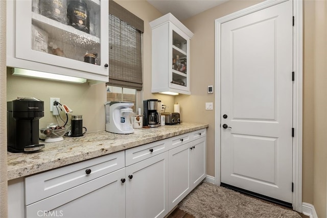 bar featuring white cabinetry and light stone counters