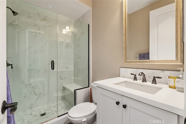 bathroom with toilet, tasteful backsplash, a marble finish shower, and vanity