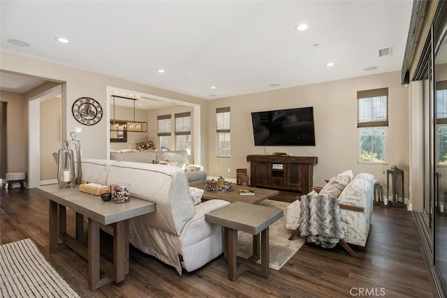 living room featuring a notable chandelier and dark wood-type flooring