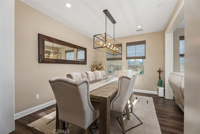 dining space featuring dark wood-type flooring and a chandelier