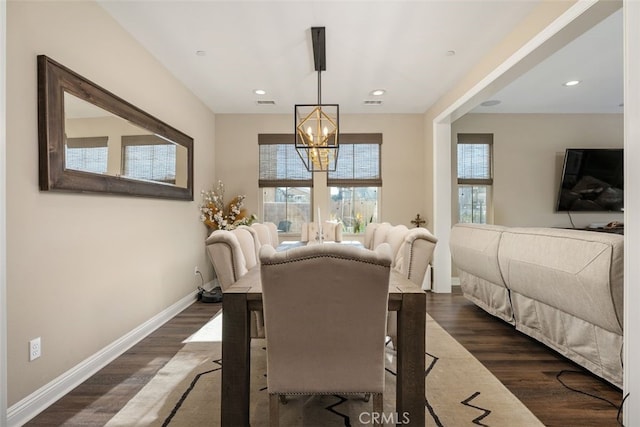 dining area with dark wood-type flooring and a chandelier