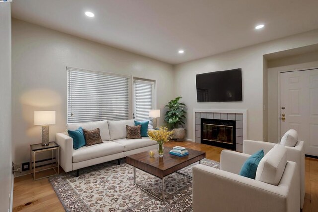 living room with a fireplace and light wood-type flooring