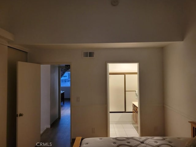 unfurnished bedroom featuring light tile patterned flooring and connected bathroom