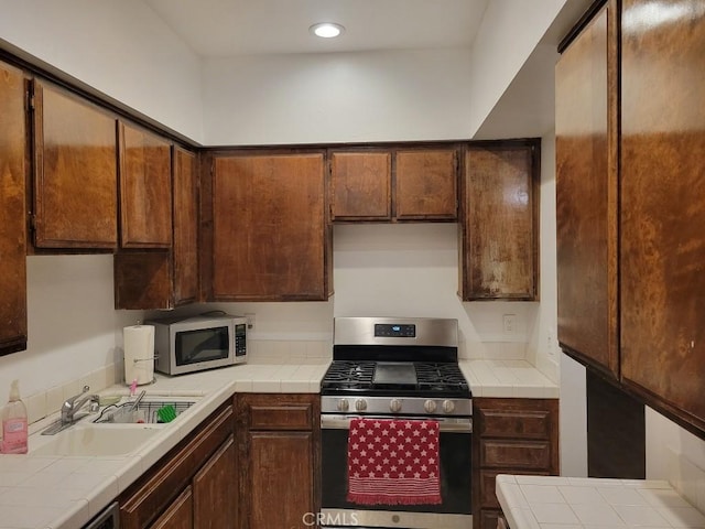 kitchen featuring sink, tile countertops, and stainless steel appliances