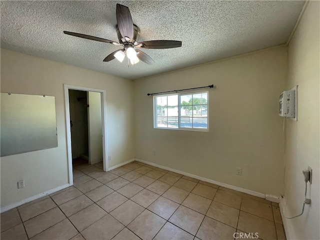 unfurnished room with ceiling fan, light tile patterned floors, and a textured ceiling