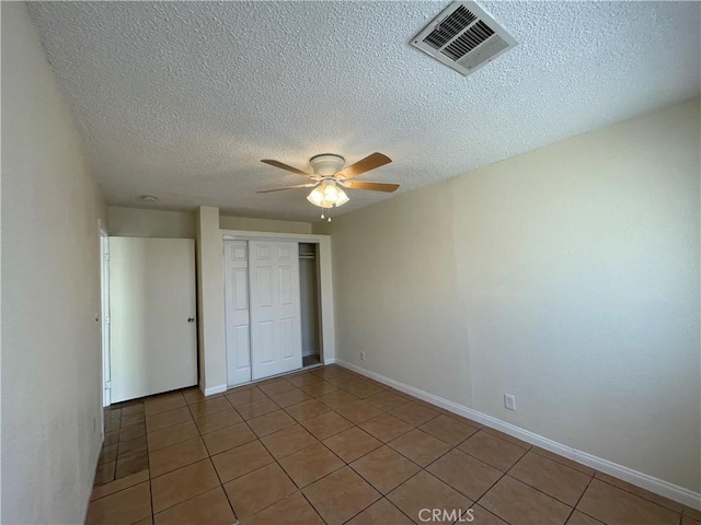 unfurnished bedroom with a closet, tile patterned floors, and ceiling fan