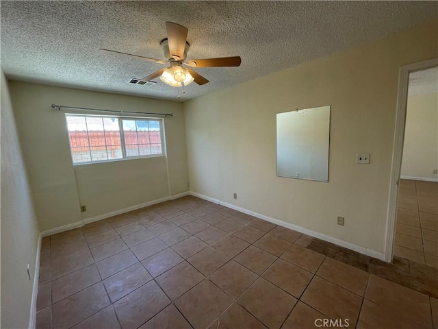 spare room with light tile patterned flooring, a textured ceiling, and ceiling fan