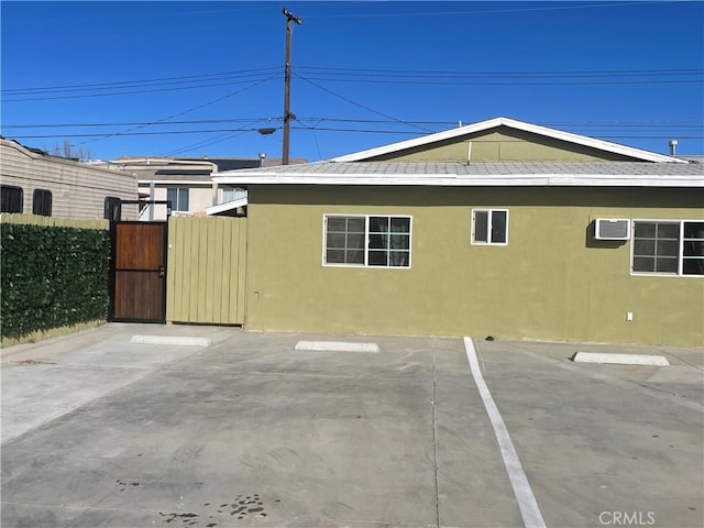 view of side of home featuring a patio area and a wall mounted AC