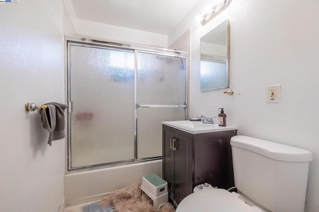 full bathroom featuring vanity, enclosed tub / shower combo, and toilet