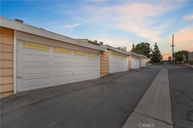 view of garage at dusk