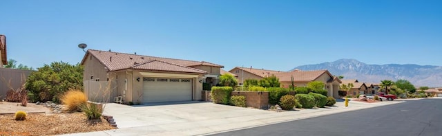 view of front of home with a garage and a mountain view