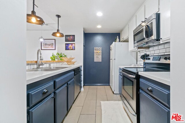 kitchen with white cabinetry, stainless steel appliances, blue cabinetry, pendant lighting, and sink