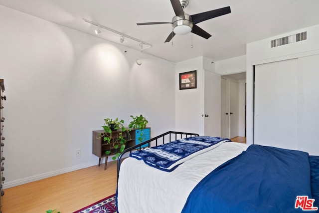 bedroom with ceiling fan, a closet, and light wood-type flooring