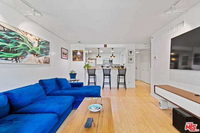 living room featuring light hardwood / wood-style flooring and rail lighting