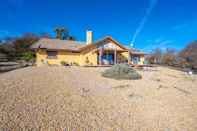 view of front of property featuring a chimney and stucco siding