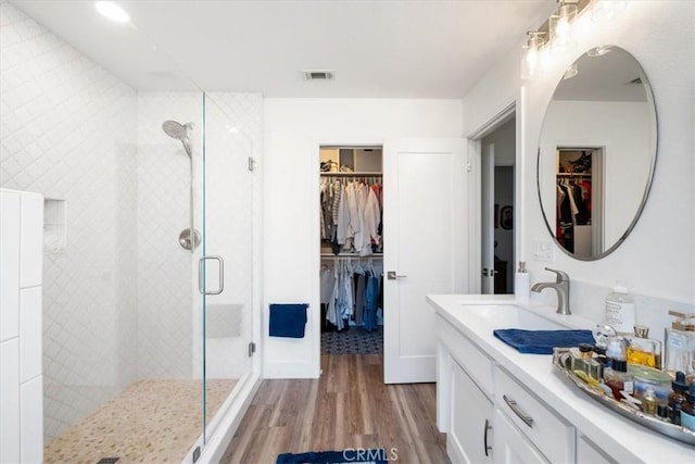 bathroom featuring walk in shower, wood-type flooring, and vanity